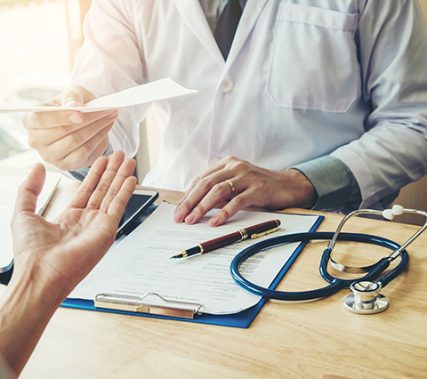 Consulta médica en Santiago Centro para atender sus malestares Médico en consulta médica Santiago Centro dando receta a paciente